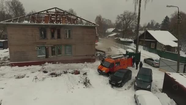 Ο εκσκαφέας κατεδαφίζει ερειπωμένο παλιό σπίτι το χειμώνα. Αεροφωτογραφία — Αρχείο Βίντεο