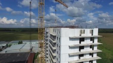 İnşaat işçileri tarlada bir apartman inşa ediyorlar, hava manzaralı.