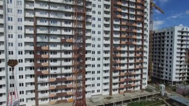 İnşaat işçileri tarlada bir apartman inşa ediyorlar, hava manzaralı.