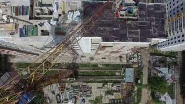 İnşaat işçileri tarlada bir apartman inşa ediyorlar, hava manzaralı.