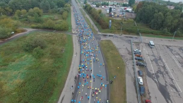 Een grote groep mensen die een marathon lopen in de buitenlucht in een stedelijke omgeving — Stockvideo