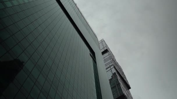 Věž obchodního centra v pozadí vybledlá obloha, vystřelená zdola nahoru — Stock video