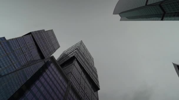 Бізнес-центр на задньому плані поблякло небо, знято знизу вгору. — стокове відео