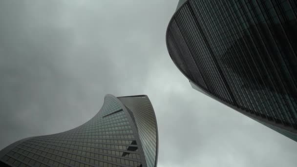 Business center toren in de achtergrond vervaagde hemel, schot van onder naar boven — Stockvideo