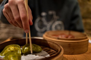 Dim sum yiyen bir adam, Asya yemekleri, çubuk kullanan bir adam. Sakallı ve kazaklı. Yaşam biçimi.