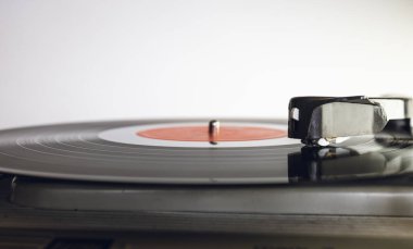 Beyaz arkaplandaki vinil pikabı kapat. Sığ alan derinliği, odaklanma seçimi.