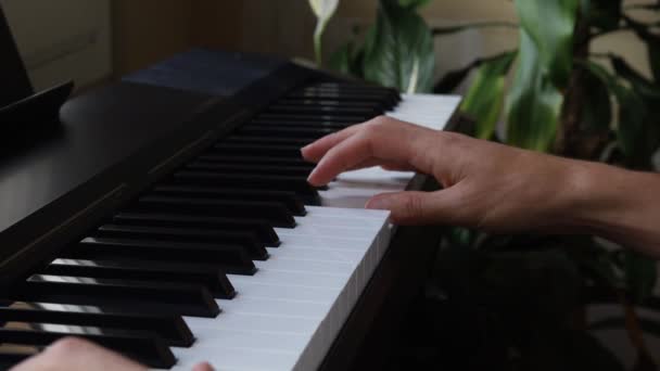 Ung Man Som Spelar Piano Ett Hus Framför Ett Fönster — Stockvideo