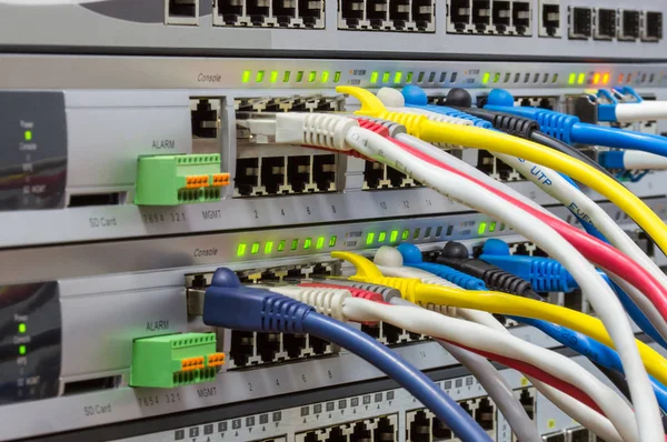 Telecommunications rack with switches and colored patch cords — Stock Photo, Image