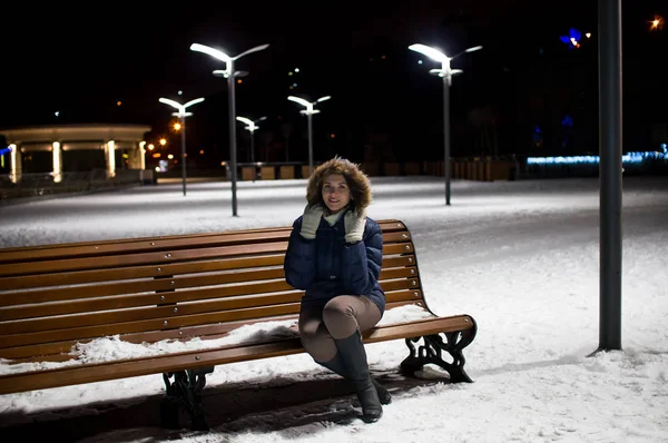 Fille sur une nuit d'hiver assis sur un banc — Photo