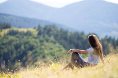 Kız dağın üzerinde oturuyor