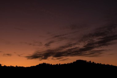Gün batımında renkli dağ manzarası. Gökyüzünde muhteşem renkleri olan sihirli günbatımı.