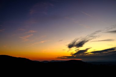 Gün batımında renkli dağ manzarası. Gökyüzünde muhteşem renkleri olan sihirli günbatımı.