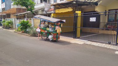 Bir sebze tüccarı, Corona salgınının ortasında bir yerleşim bölgesinde satış yapıyor.