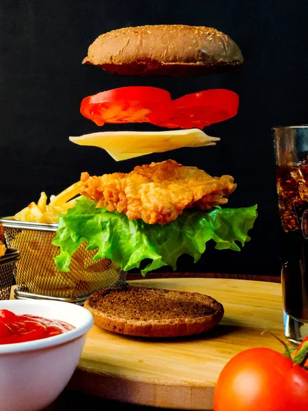Hamburger malzemeleri havaya uçuyor ve patates kızartması.