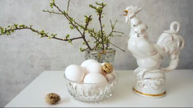 Mutlu Paskalyalar Bir bahar buketi, yumurtalar ve seramik bir horoz. Bir yumurta sürekli dönüyor.