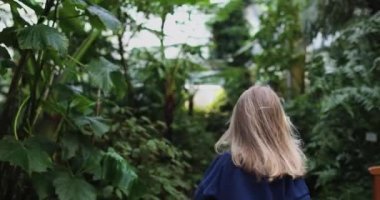 Orman elbiseli küçük bir kız kameradan kaçıyor.