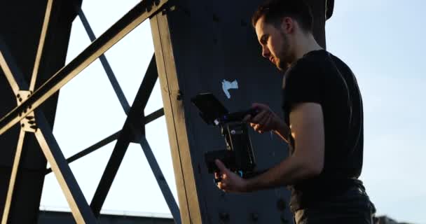 Handsome Male young caucasian Filmmaker in black with beard film handheld. — Stock Video