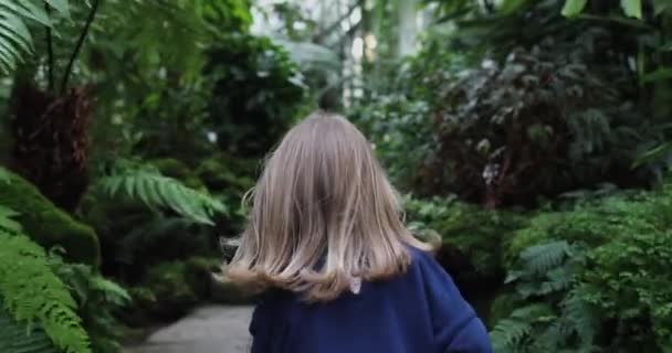 Маленькая девочка в джунглях убегает от камеры — стоковое видео