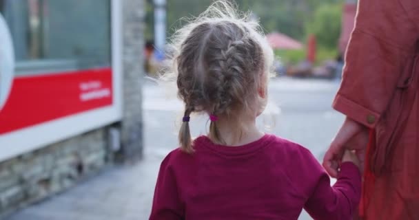 Familie concept. Jonge moeder en kind dochter houden handen en wandeling — Stockvideo