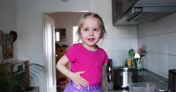 Petite fille blonde en rose Cuisine et jouer dans la cuisine — Video