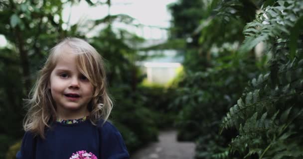 En liten flicka i en djungelklänning springer iväg från kameran — Stockvideo