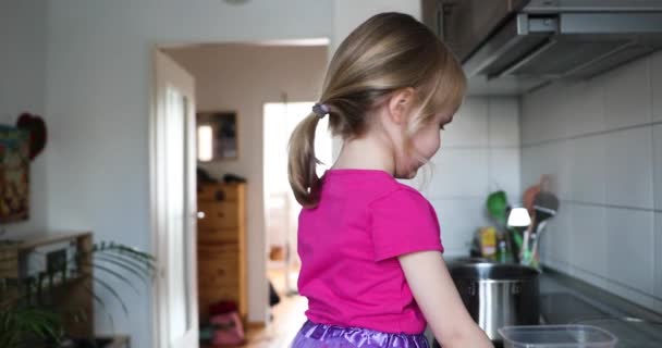 小さなブロンド女の子でピンク料理とプレイでザ · キッチン — ストック動画