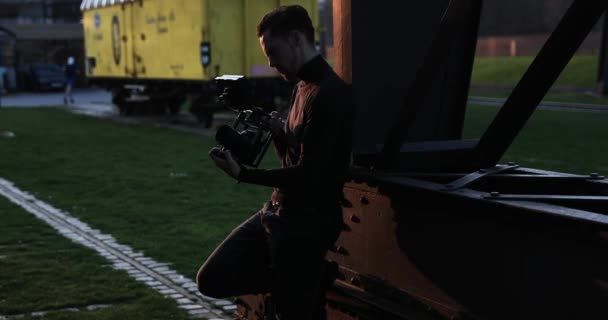 Filmmaker camera handheld bij zonsondergang in een grote stad. Mensen rennen op de achtergrond — Stockvideo