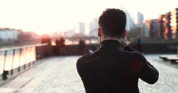 男性摄影师使用DSLR相机拍照。法兰克福日落天空线 — 图库视频影像