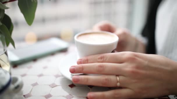 Κορίτσι πίνει καφέ σε ένα καφέ — Αρχείο Βίντεο