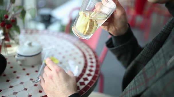 De man in het café drinkt thee en kijkt uit het raam. — Stockvideo