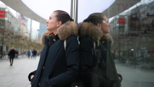 Hermosa rubia se refleja en una ventana en la calle de la ciudad — Vídeos de Stock