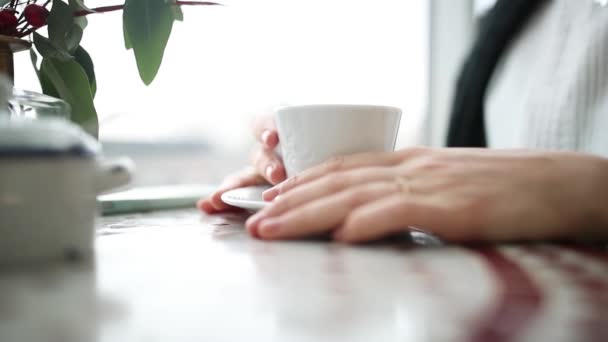 Handen van een meisje dat koffie drinkt — Stockvideo