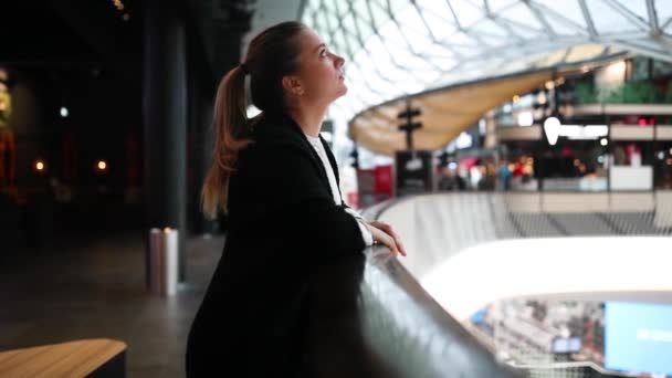 Blondynka w centrum handlowym patrzy na szklaną kopułę — Wideo stockowe