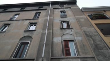 Kemerli pencereleri olan eski bir evin altında çadırı olan modern bir kafe.