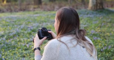  Sarışın mutlu bir şekilde fotoğraf çekiyor. Ormanda çiçek açarken.