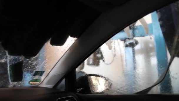 Vista a través del parabrisas y la ventana lateral en el lavado de coches — Vídeo de stock