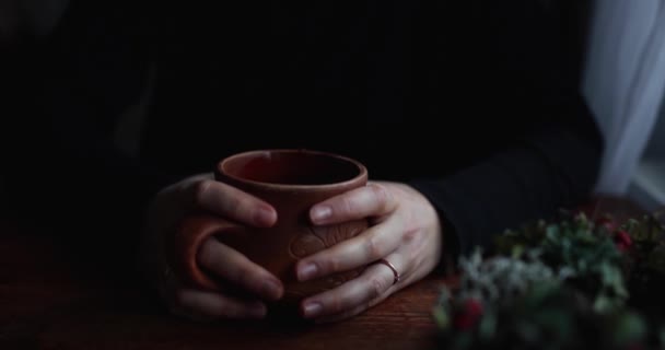 Close-up handen op tafel gelegd een bruine keramische mok — Stockvideo