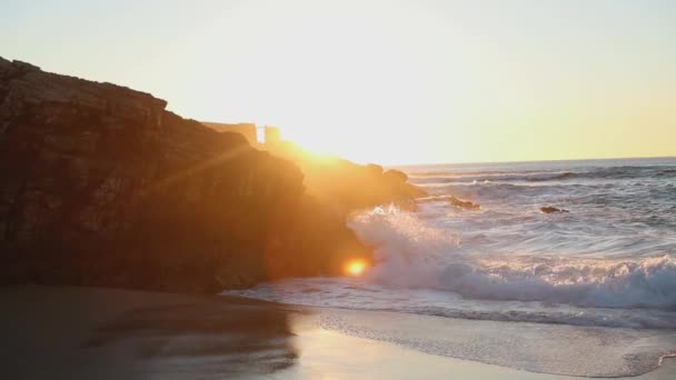 Köpüklü okyanus dalgaları gün doğumunda sakince kıyıya vurur. — Stok video