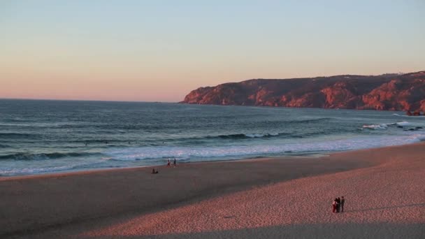 Світлові хвилі на пустельному березі океану на тлі скель — стокове відео