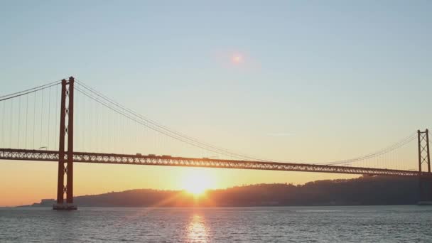 Nascer do sol sobre a margem do rio contra a ponte — Vídeo de Stock