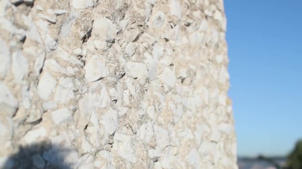 Cerca de la pared de piedra blanca contra el fondo de la orilla y el puente rojo — Vídeos de Stock