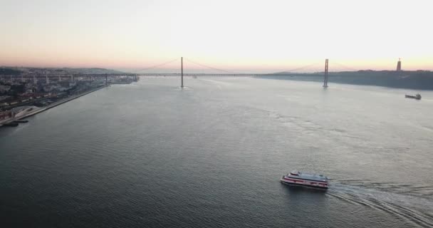 Říční loď pluje přes řeku za úsvitu proti modré bezmračné obloze — Stock video