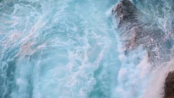 Les vagues bleues de l'océan se brisent contre les falaises rocheuses du rivage — Video