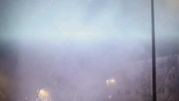 Varios fuegos artificiales explotan en la calle de la ciudad y en el cielo — Vídeo de stock