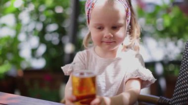 Güzel sarışının elinde meyve suyu dolu bir bardak var. 