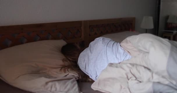 Chica con el pelo largo y rubio duerme en una cama de madera — Vídeos de Stock