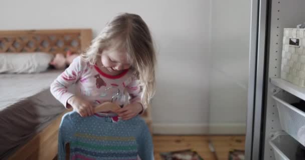 Маленька красива дівчинка з білим волоссям вибирає одяг у шафі — стокове відео