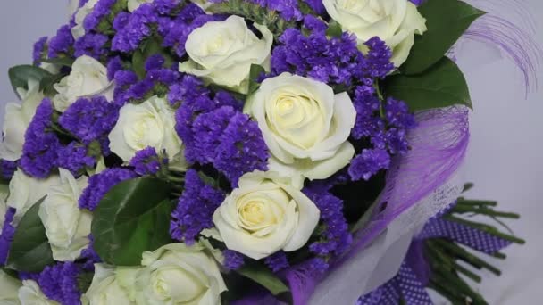 weiße Rosen Blumenstrauß mit violettem Dekor. Bewegung von rechts nach links.