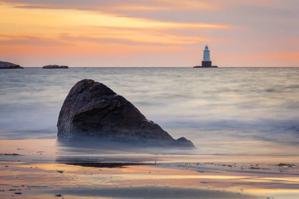 Seascape skaliste wybrzeża latarnia morska o zachodzie słońca Obrazek Stockowy