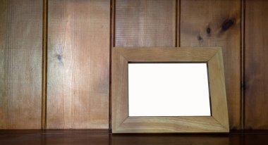 Ahşap zemine karşı ahşap tezgahın üzerindeki boş ahşap resim çerçevesini düzenle.